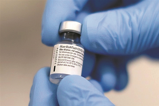 12月8日,在英国贝尔法斯特,医护人员展示一瓶新冠疫苗 新华社发